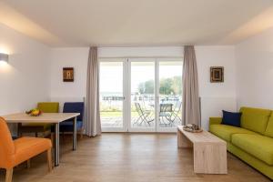 een woonkamer met een groene bank en een tafel bij 2 Zimmerapartment Nr45 P6A2 in Plau am See