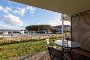 een tafel en stoelen op een veranda met uitzicht op een jachthaven bij 2 Zimmerapartment Nr45 P6A2 in Plau am See