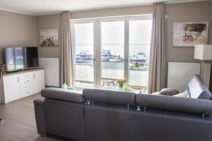 sala de estar con sofá y ventana grande en 4 Zimmer Maisonette 3 Balkone Haus 7 A 6, en Plau am See