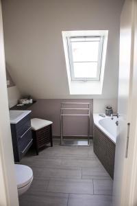 baño con lavabo, bañera y ventana en 4 Zimmer Maisonette 3 Balkone Haus 7 A 6, en Plau am See