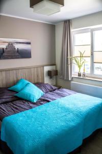 Un dormitorio con una cama azul y una ventana en 4 Zimmer Maisonette 3 Balkone Haus 7 A 6 en Plau am See