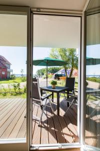 a screened porch with a table and chairs and an umbrella at Hafendorf Haus 5 Apartment 2 Nr25 in Plau am See