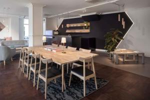 a dining room with a wooden table and chairs at Hotel Light in Rotterdam