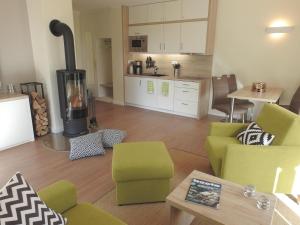 a living room with a green couch and a stove at Apartment PlauSeelig mit Bootsliegeplatz optional in Plau am See