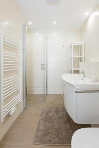 a white bathroom with a sink and a shower at Hafendorf Haus 7_ Apartment 4 in Plau am See