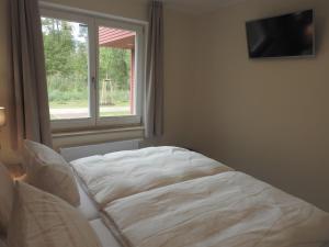 a white bed in a room with a window at Apartment PlauSeelig mit Bootsliegeplatz optional in Plau am See