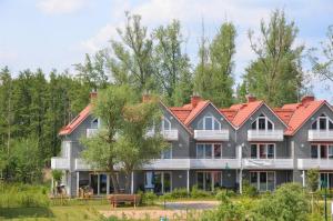 a large house with a red roof at Apartment PlauSeelig mit Bootsliegeplatz optional in Plau am See