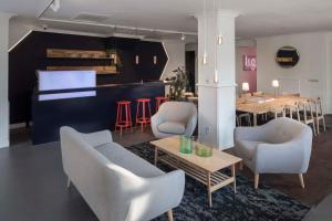 a living room with chairs and tables and a bar at Hotel Light in Rotterdam
