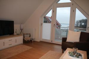 uma sala de estar com televisão e uma grande janela em Hafendomizil Haus 5 Apartment 8 em Plau am See
