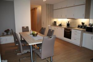 プラウ・アム・ゼーにあるHafendomizil Haus 5 Apartment 8のキッチンにテーブルと椅子がある