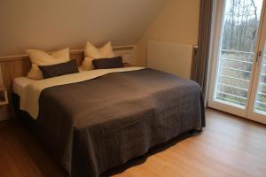 - un grand lit dans une chambre avec une grande fenêtre dans l'établissement Hafendomizil Haus 5 Apartment 8, à Plau am See