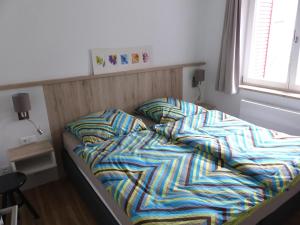 an unmade bed in a small bedroom with a window at Haus 6 Apartment 3 in Plau am See