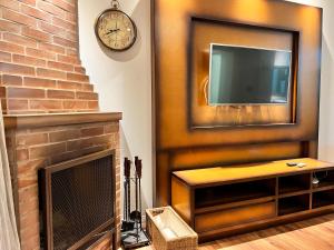 un soggiorno con camino e TV di Home GRAMADO- 400 metros da Rua Coberta a Gramado