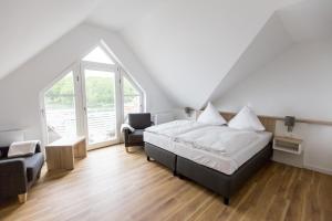 a bedroom with a bed and a chair and a window at Whg_ _Hafenparadies_ P6A7 optional in Plau am See