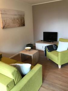 a living room with two couches and a tv at Hafendorf Haus 5_ Apartment 3 in Plau am See
