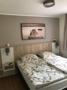 a bedroom with a bed with a picture on the wall at Hafendorf Haus 5_ Apartment 3 in Plau am See