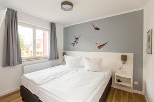 a bedroom with a white bed and a window at Maisonette Jocki P6 A9 in Plau am See