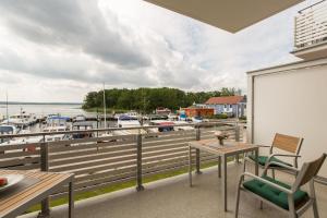 uma varanda com mesas e cadeiras e uma marina em Maisonette Jocki P6 A9 em Plau am See
