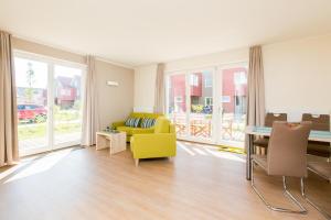 a living room with a yellow couch and a table at Hafenperle P5A5 Nr37 in Plau am See