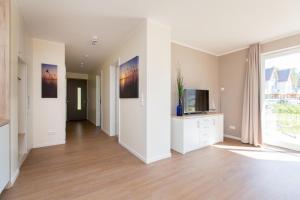 an empty living room with a tv and a large window at Hafenperle P5A5 Nr37 in Plau am See