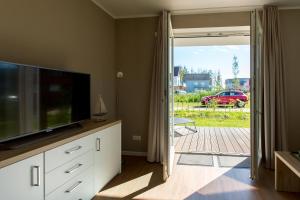 ein Wohnzimmer mit einem TV und einer Glasschiebetür in der Unterkunft Hafenperle P5A5 Nr37 in Plau am See