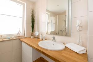a white bathroom with a sink and a mirror at Hafenperle P5A5 Nr37 in Plau am See +9 photos