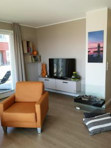 sala de estar con TV y silla en 2 Zimmerapartment 2 Terrassen P7a1 en Plau am See