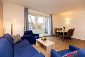 a living room with a blue couch and a table at Apartment mit 3 Schlafzimmer P5A7 in Plau am See