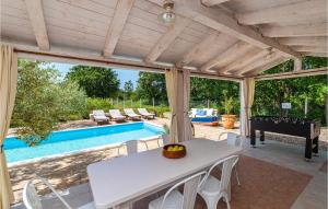 um pátio com uma mesa, um piano e uma piscina em Gorgeous Home In Posedarje With Kitchen em Posedarje