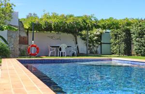 a swimming pool with a table and chairs next to a house at Chalet Dehesa Villa in Conil de la Frontera +15 photos
