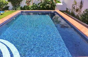 a swimming pool with blue water in a yard at Chalet Dehesa Villa in Conil de la Frontera