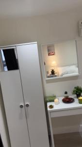 1 dormitorio con armario blanco y espejo en Lovely Studio Apartment in London, en Londres