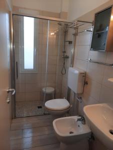 uma casa de banho com um WC, um chuveiro e um lavatório. em Residence Holiday em Bellaria-Igea Marina