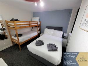 a small room with two beds and a bunk bed at Palatine Court Holiday Flats - Blackpool Resort Collection in Blackpool