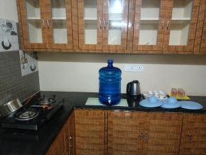 ADVIK HOMESTAYS في تيروباتي: وجود زجاجة مياه زرقاء كبيرة على طاولة المطبخ
