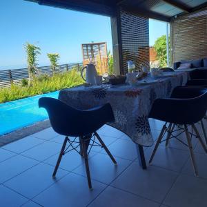 a dining table and chairs with a view of the ocean at La kazanou in Saint-Joseph