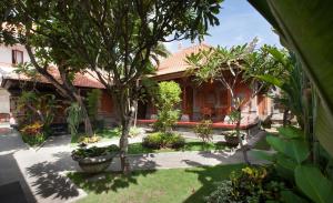 a house with trees and plants in a yard at Nesa Sanur Bali in Sanur