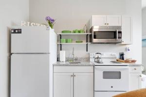 a white kitchen with a refrigerator and a microwave at Suite One King Bed 2TVs Free Parking & museums in Richmond