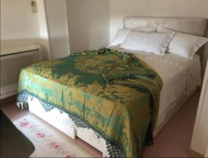 ein Schlafzimmer mit einem Bett mit einer grünen Decke darauf in der Unterkunft CasettaRosa in Battipaglia