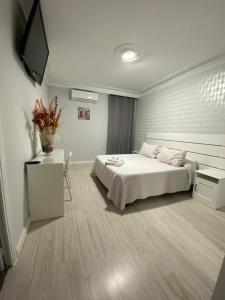 1 dormitorio con cama, mesa y TV en Hostal Fuente del Pino, en Jumilla