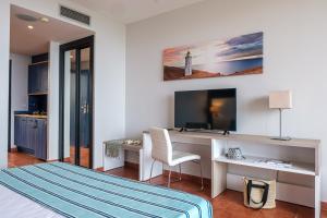 a bedroom with a bed and a desk with a television at Estival Islantilla in Islantilla