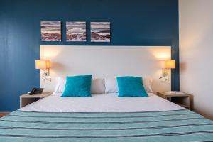 a bedroom with a large bed with blue walls at Estival Islantilla in Islantilla