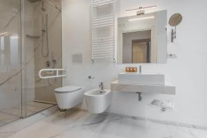 La salle de bains blanche est pourvue de toilettes et d'un lavabo. dans l'établissement RG7 Apartments, à Catane