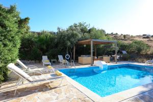 a swimming pool with chairs and a gazebo at Listaros Villas in Lístaros