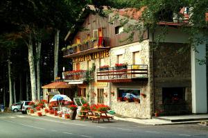 um edifício com mesas e guarda-sóis ao lado de uma rua em Albergo Generale Cantore - Monte Amiata em Abbadia San Salvatore