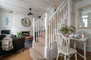 a white staircase in a living room with a table and chairs at Anchor Cottage in Dartmouth