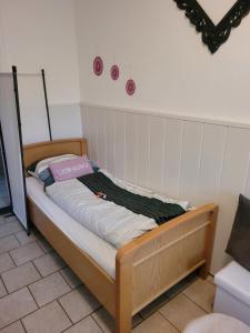 ein kleines Bett in einem Zimmer mit rosa und lila Dekorationen in der Unterkunft Ingrid&primes Ferienwohnung in Erfde