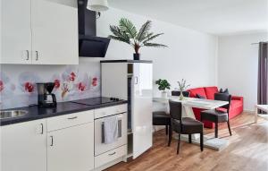a kitchen with white cabinets and a table with chairs at 1 Bedroom Gorgeous Apartment In Passow Ot Charlottenho in Zahren