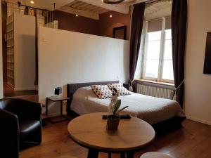une chambre d'hôtel avec un lit et une table dans l'établissement Maison d'Eusébia, à Château-Chalon