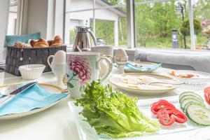 a table with plates of food on it at Villa Jokivarsi Bed & Breakfast in Vantaa +27 photos